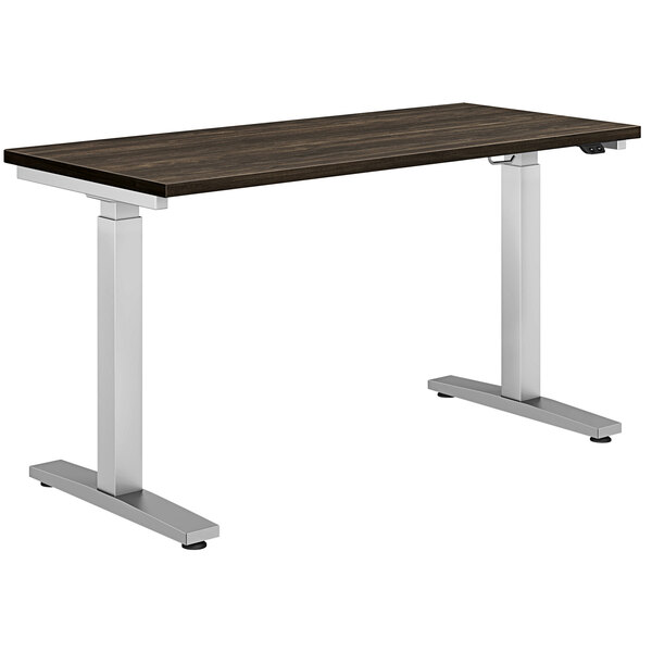 A HON Coze height-adjustable desk with a walnut top and silver legs.