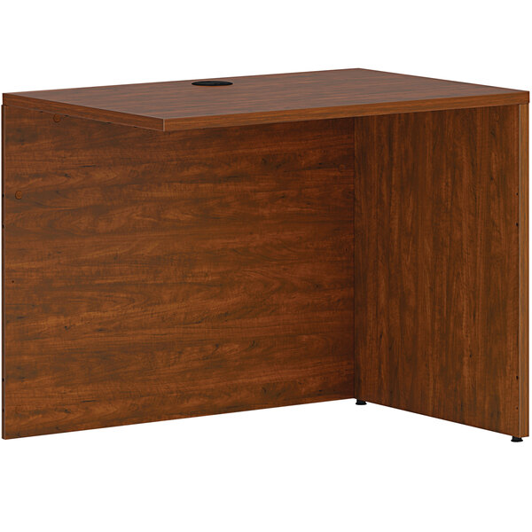 A HON russet cherry desk return shell with a wooden top and a hole in the top.