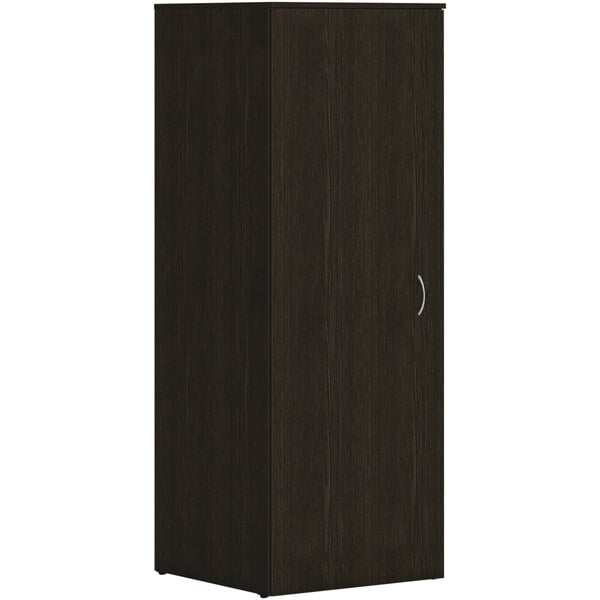 A HON Java Oak laminate wardrobe with a door and silver handles.