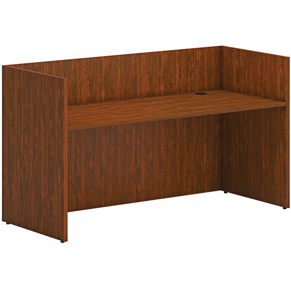A russet cherry HON reception desk shell with a shelf and a drawer.