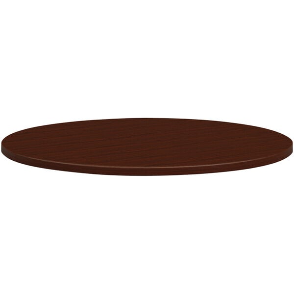 A HON mahogany laminate round conference table top.