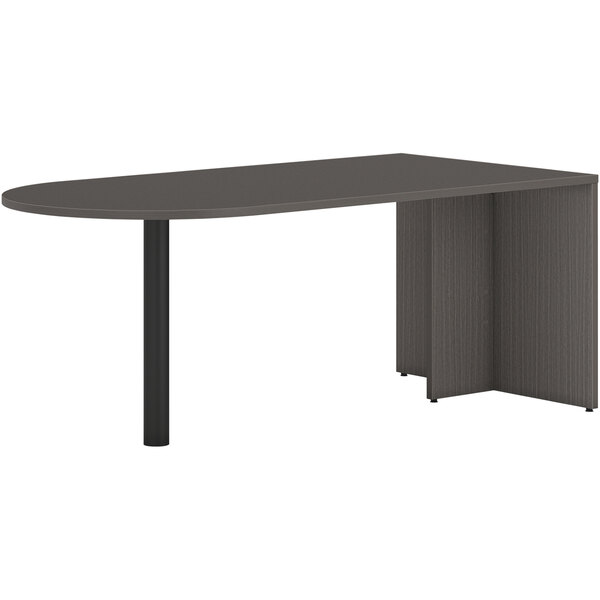 A slate teak HON Peninsula desk with end panel and black base.