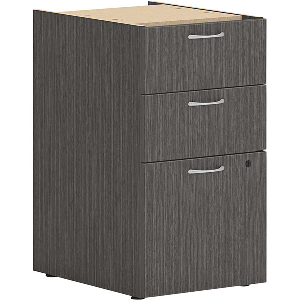 A slate grey HON pedestal file cabinet with a wooden top open.