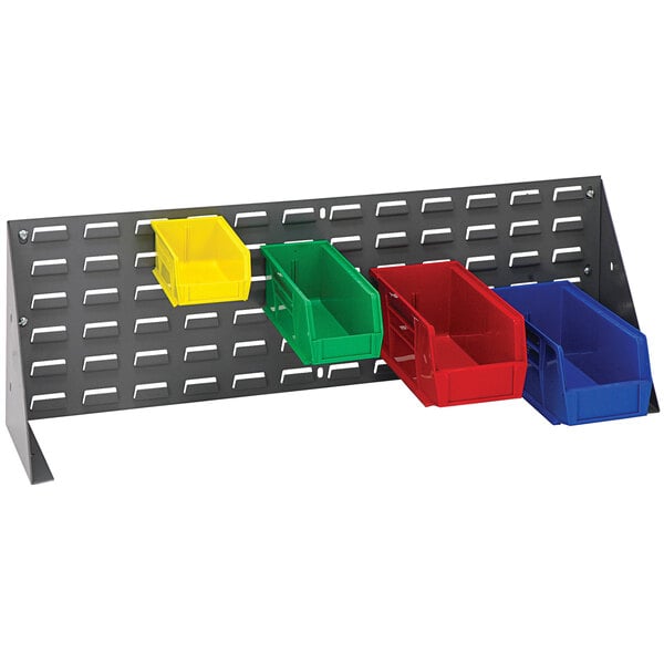 A Quantum grey steel bench rack with blue, red, and green plastic bins on a wall.