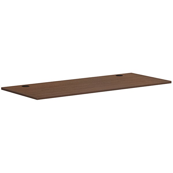 A brown rectangular HON worksurface with two holes.