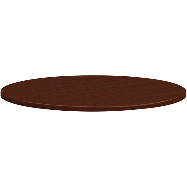 A HON mahogany laminate round conference table top.