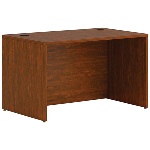 A russet cherry laminate HON desk shell on a wooden desk.