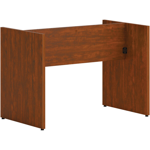 A HON russet cherry laminate slab base on a wooden conference table.