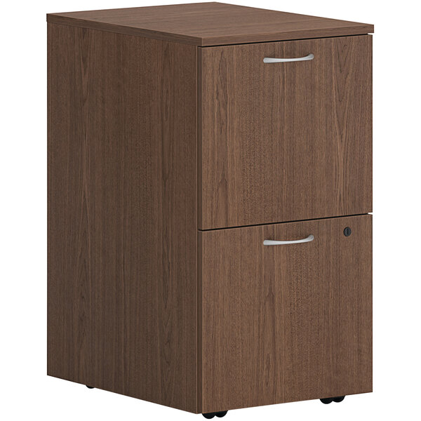 A brown HON mobile pedestal filing cabinet with 2 file drawers and silver handles.