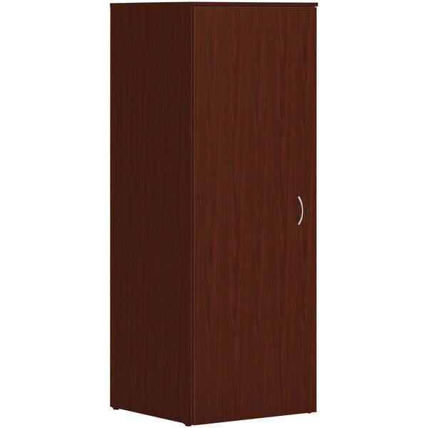 A close-up of a traditional mahogany HON wardrobe cabinet with a door and silver handles.