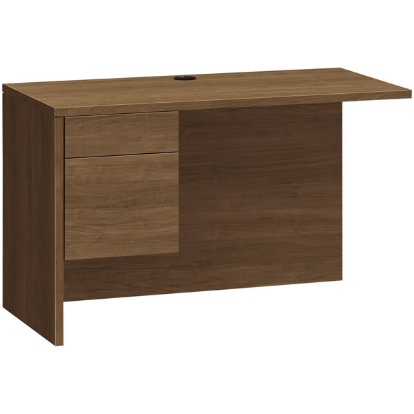 A brown wooden HON desk return with a box drawer and a file drawer.