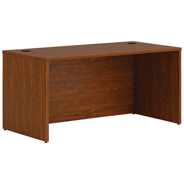 A russet cherry laminate HON desk shell with two holes in the top.