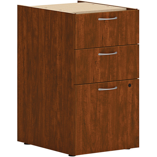 A russet cherry wooden file cabinet with a box support pedestal and 1 file drawer.