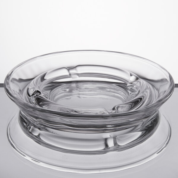 A clear glass ashtray with a circular rim.