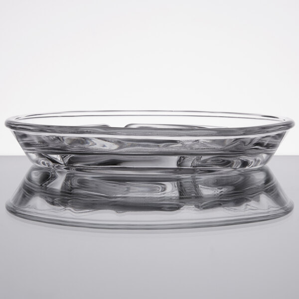 A clear glass Libbey safety ashtray on a counter.