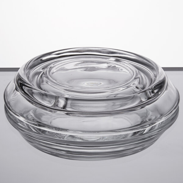 A clear glass Libbey ashtray with a spiral pattern on a table.