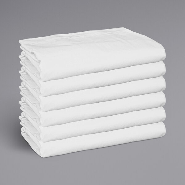 A stack of white Monarch Brands fitted sheets.