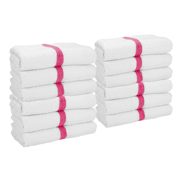 Two stacks of white towels, each with a pink stripe down the center, are neatly folded and arranged side by side.