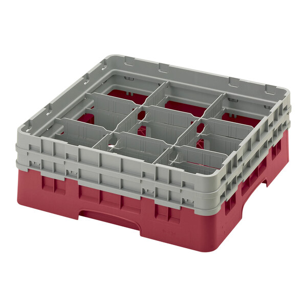A red and grey plastic Cambro glass rack with compartments and extenders.