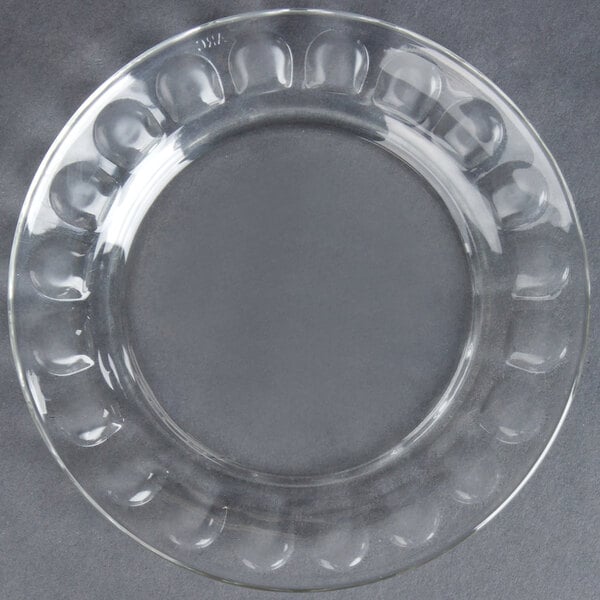 A clear glass Arcoroc dessert plate with a circular design.