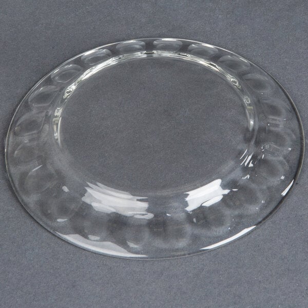A clear glass Arcoroc dessert plate with a circular design.