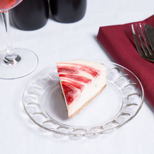 A slice of strawberry cheesecake on an Arcoroc clear glass dessert plate.