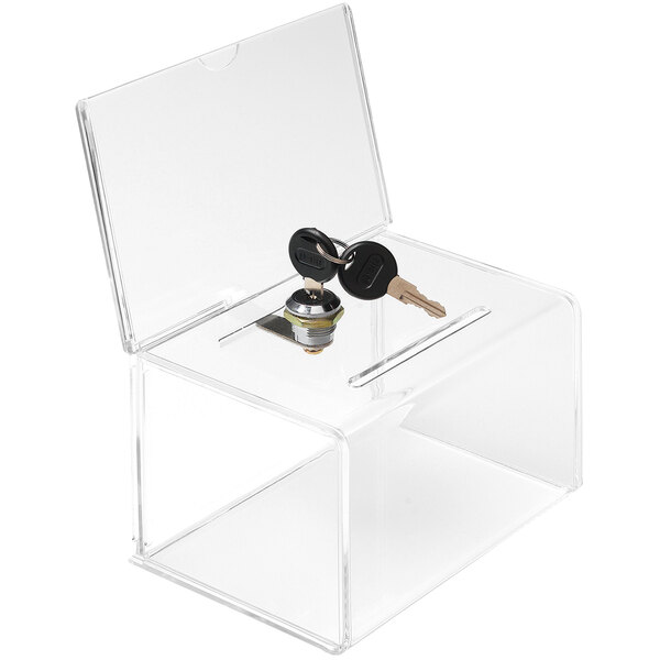 A clear acrylic Deflecto ballot box with a lock on a table.