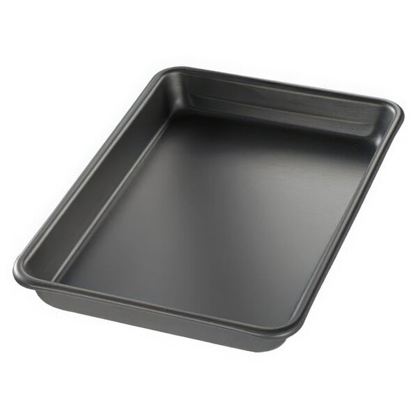 A black Chicago Metallic BAKALON aluminum sheet pan with curled edges on a counter.