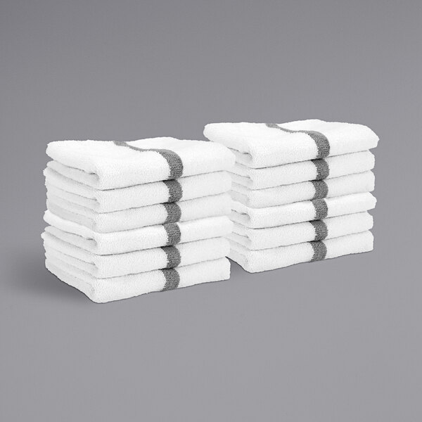 A stack of white towels with a gray center stripe.