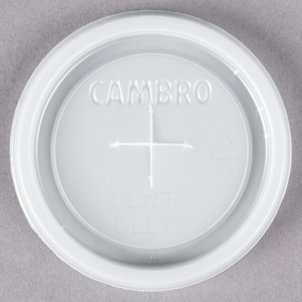 A white plastic Cambro lid with a straw slot and a cross on it.