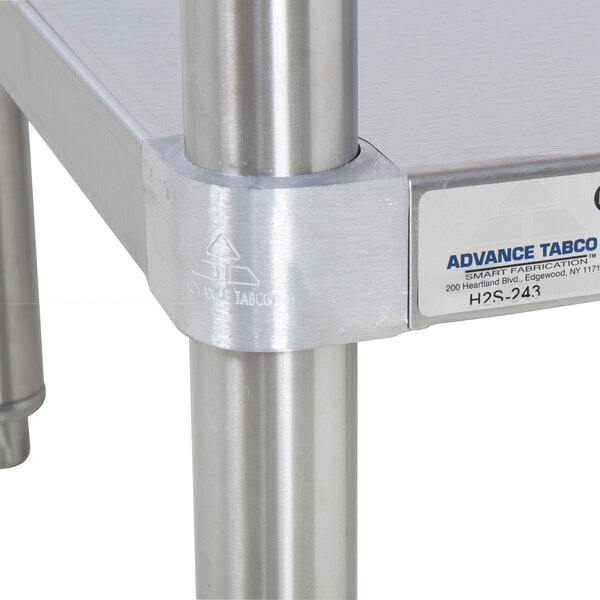 An Advance Tabco wood top work table with stainless steel base and undershelf.