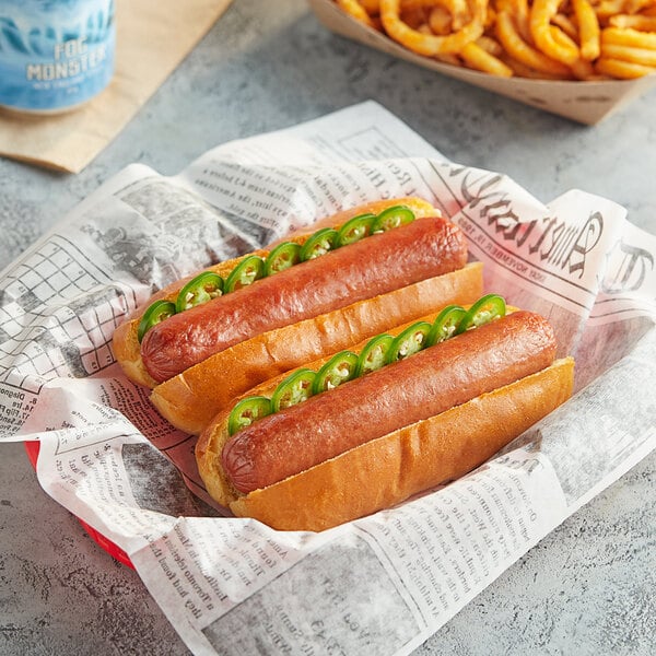 Two Nathan's Famous jalapeno and cheese hot dogs with onions and jalapenos in a blue newspaper basket.