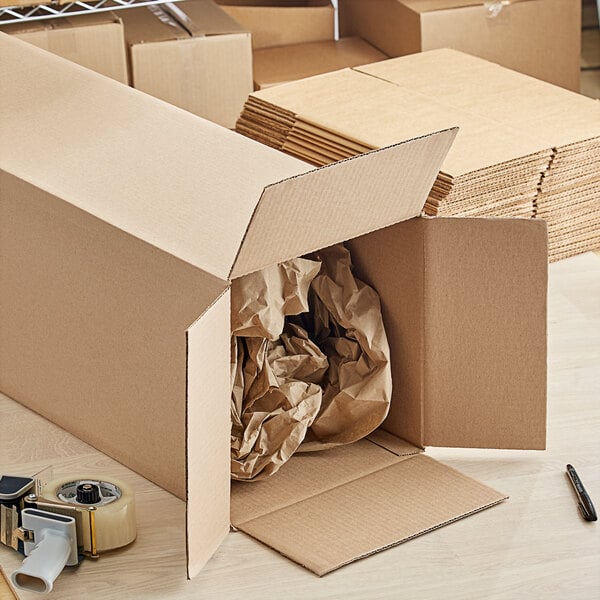 A close-up of a Lavex kraft cardboard shipping box with brown paper inside.