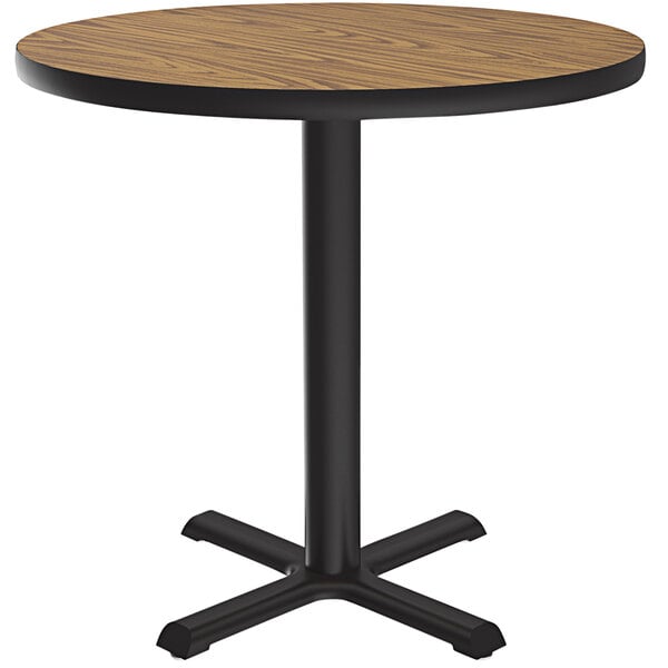 A Correll round table with a medium oak finish and black base.