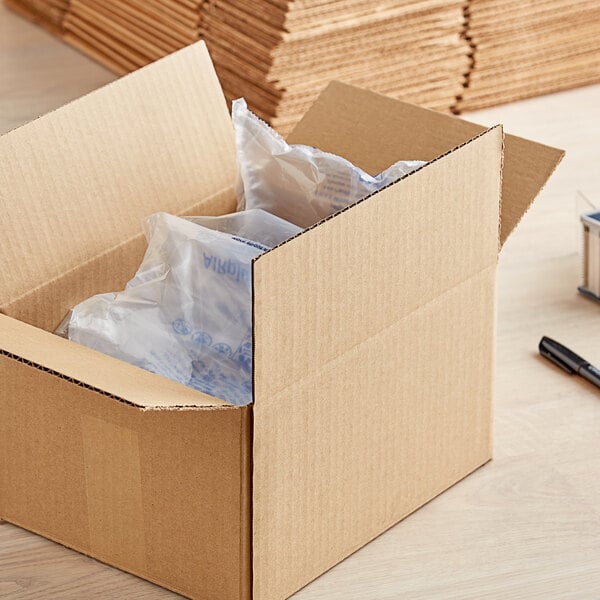 A Kraft cardboard shipping box with a pen and paper on top.