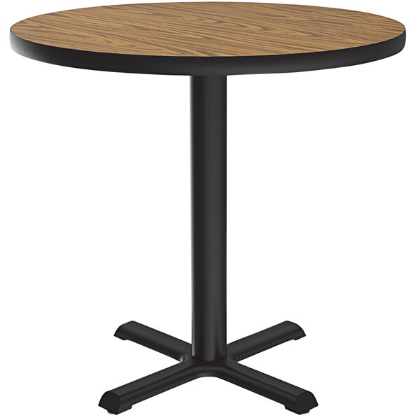 A Correll round table with a black base and a wooden top.