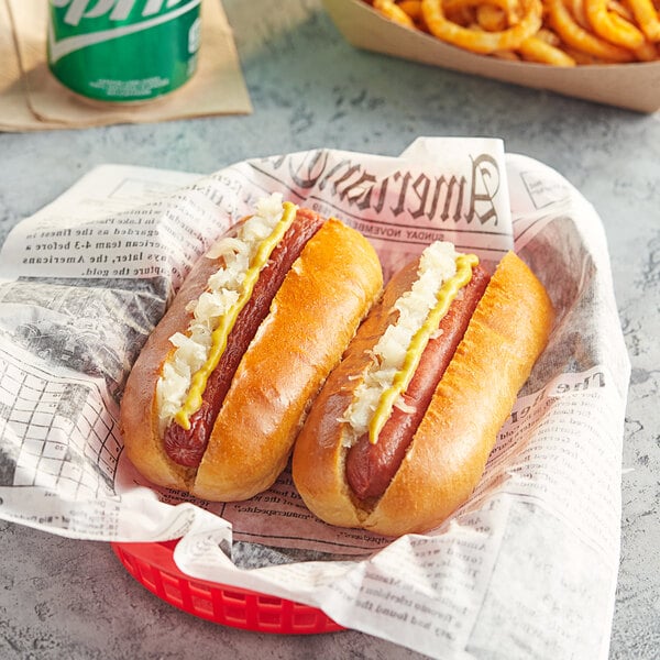 Two Nathan's Famous beef hot dogs with ketchup and mustard on a paper plate.