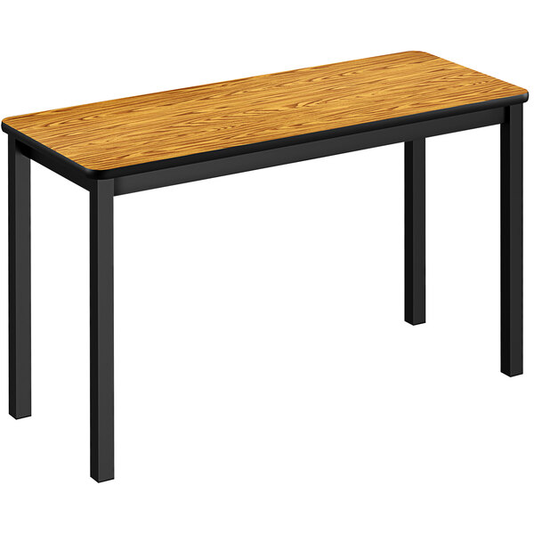 A Correll medium oak rectangular table with black legs.