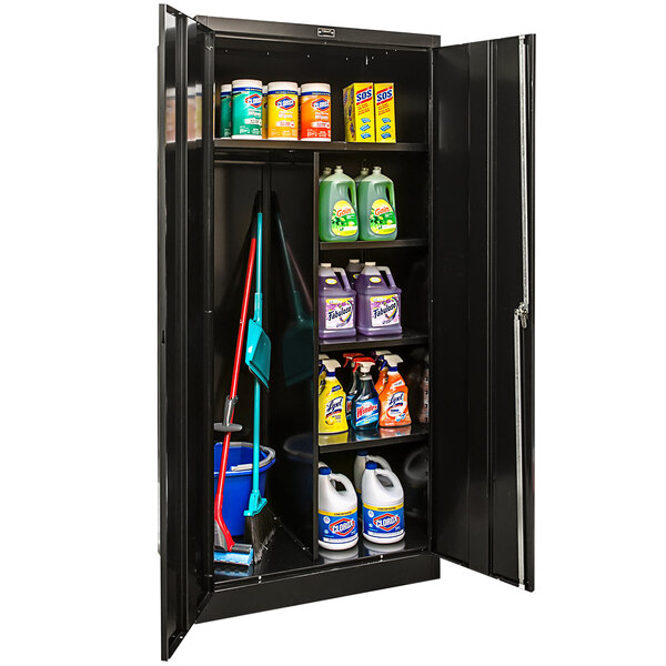 A black metal Hallowell storage cabinet with cleaning supplies on a shelf.