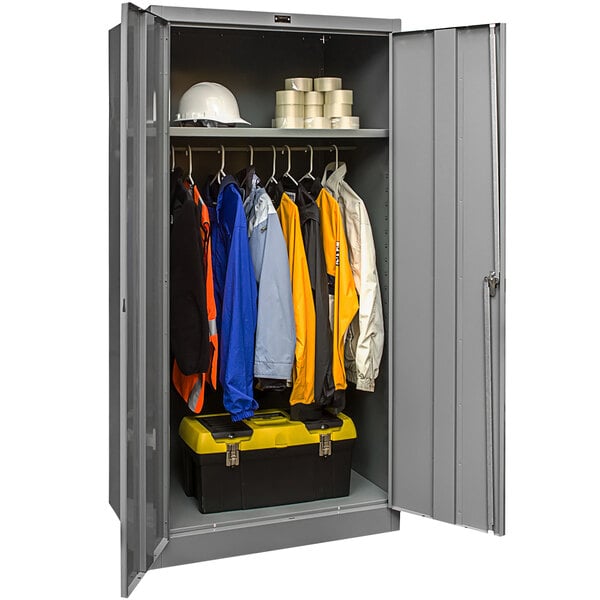 A gray steel Hallowell wardrobe cabinet with solid doors filled with clothes.