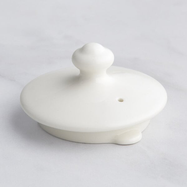 A white round lid for a coffee pot with a small round knob on top.