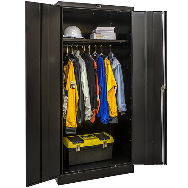 A black metal wardrobe cabinet with solid doors filled with clothes and a toolbox.