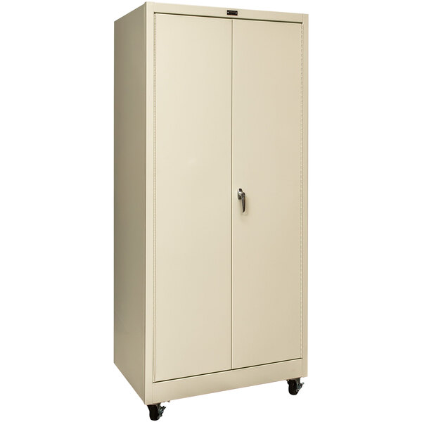 A tan metal mobile storage cabinet with wheels.