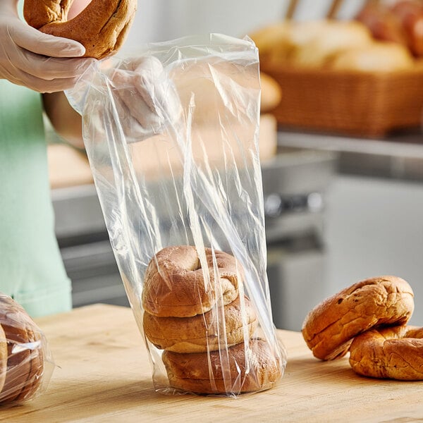 A person in gloves holding a stack of bread in a Choice plastic bag.