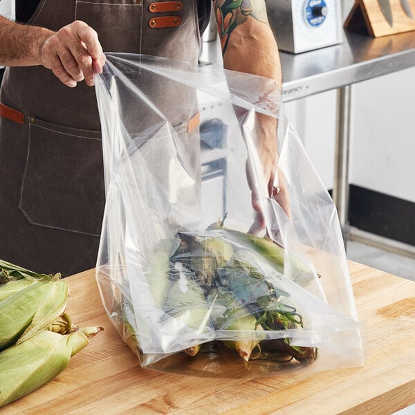 A person holding a Choice heavy-duty plastic bag of corn on the cob.