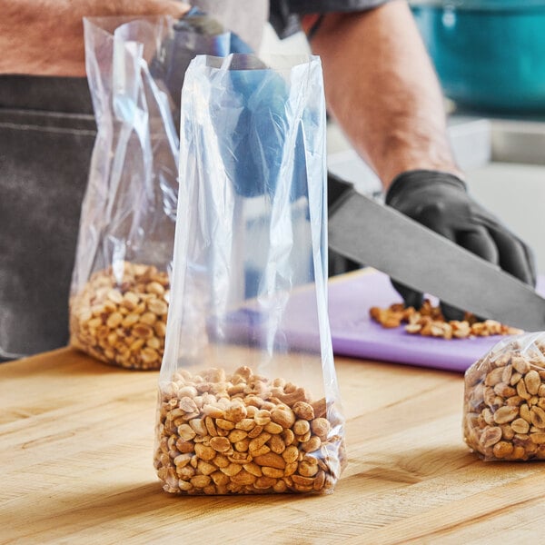 A person cutting nuts in a Choice plastic bag on a table.