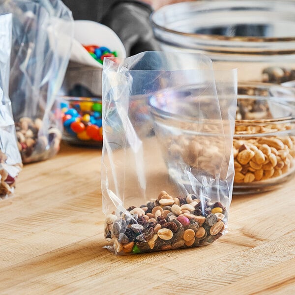 A table with a bag of nuts and snacks with a Choice heavy-duty plastic food bag on it.