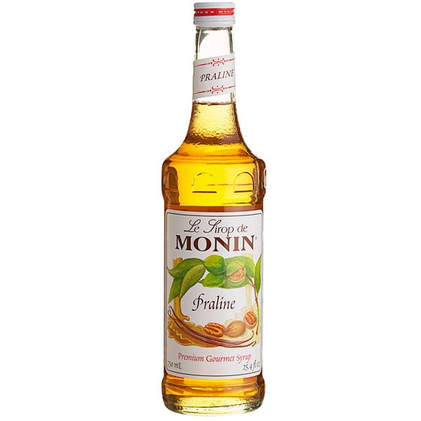 A Monin Praline flavoring syrup bottle with a label.