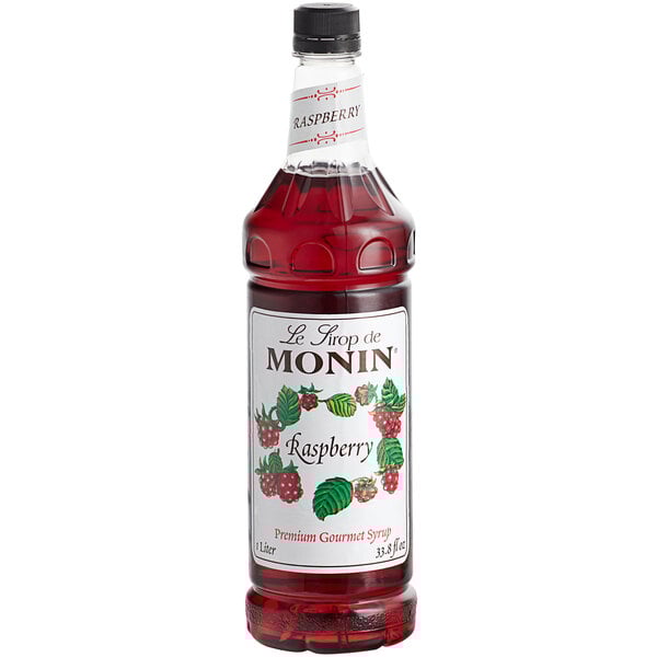A close up of a Monin Raspberry Syrup bottle.