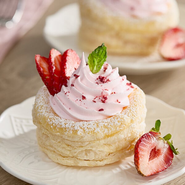 A dessert on a plate with whipped cream and strawberries.